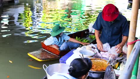 vendors preparing food on boats in bangkok