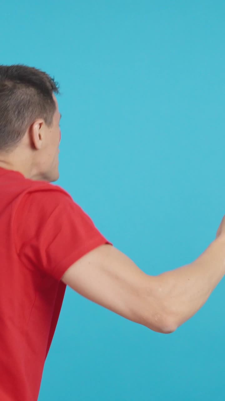 Rear view of a man waving a canadian pennant