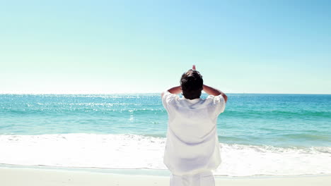 man meditating on the beach