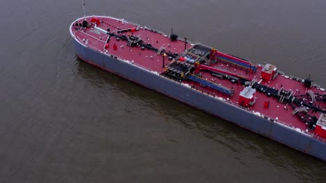 aerial backward tilt-up reveal of barge on hudson river, usa