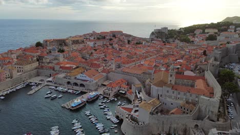 dubrovnik harbor and cityscape with boats docked and people roaming walled streets, framed by scenic adriatic views