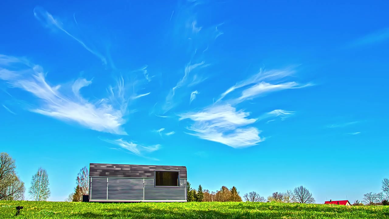 Gruppo di amici che fa colazione al mattino accanto a una baita con il sole che sorge contro il cielo blu. Time-lapse, inquadratura fissa