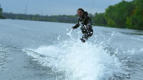 young man on wakeboard dissecting river waves in slow motion. extreme holidays