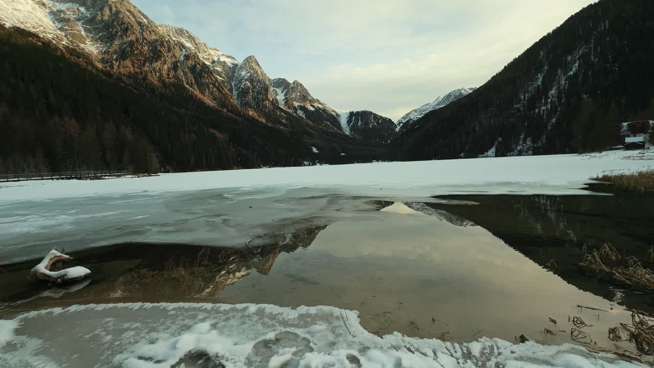 Lago alpino ghiacciato all'alba