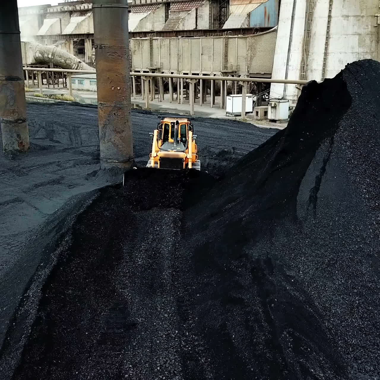 Crawler bulldozer sorts coal. Industry. Aerial view.