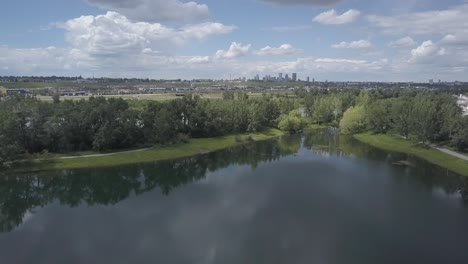 Horizonte-De-La-Ciudad-Con-Un-Estanque-En-Primer-Plano