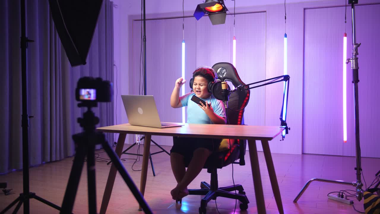 Asian Little Boy Playing Video Game With Mobile Phone Then Celebrating While Live Stream, Professional Light Equipment