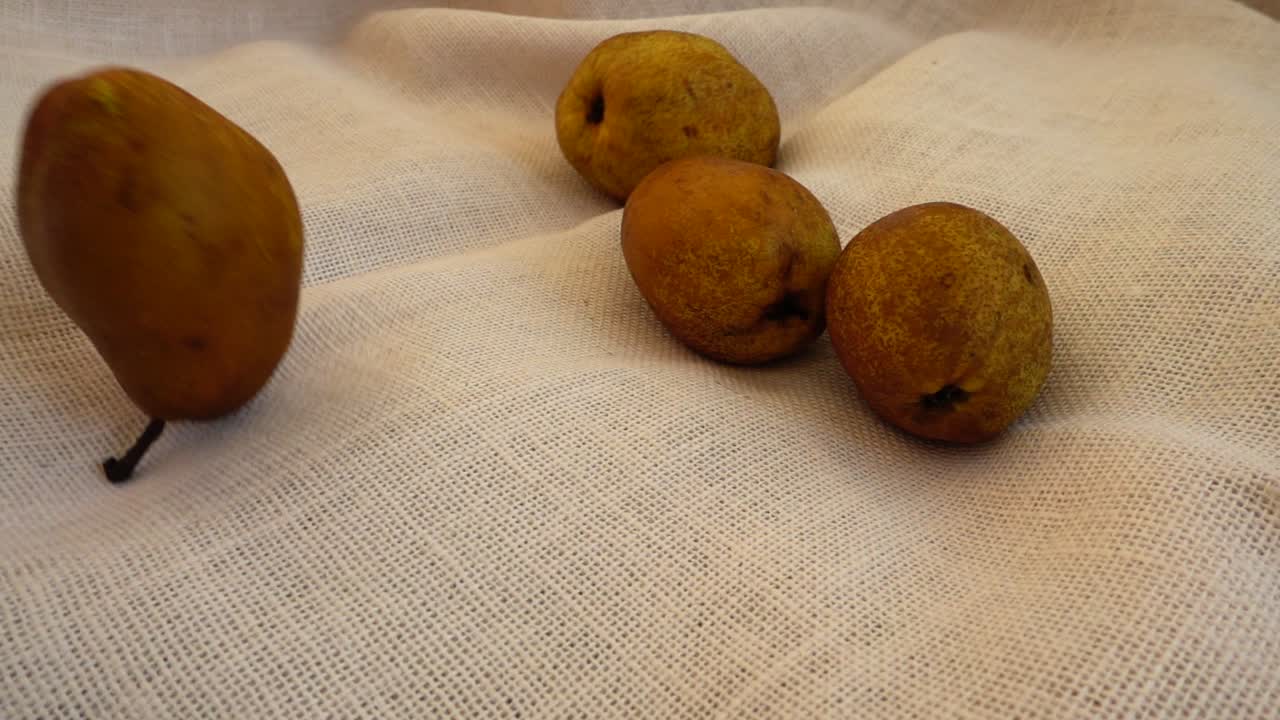 Buah Pir Matang Jatuh ke Atas Kain Bertekstur