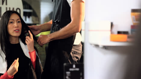 peluquero masculino peinando el cabello de una mujer