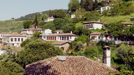 House-with-smoking-chimney-pot-on-red-Turkish-tiled-roof-hillside-village