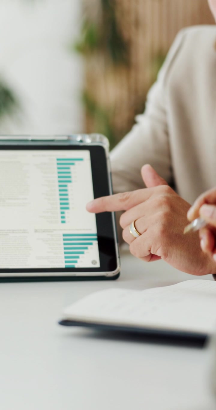 Erhvervsfolk der diskuterer datadiagrammer på en tablet på kontoret