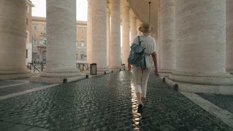 Woman walking among columns in Vatican City
