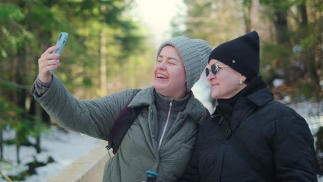 two friends taking a selfie in a winter forest