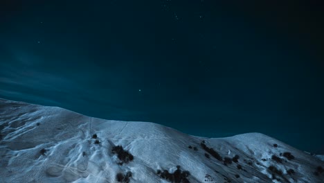 stars above snow-capped mountains at night