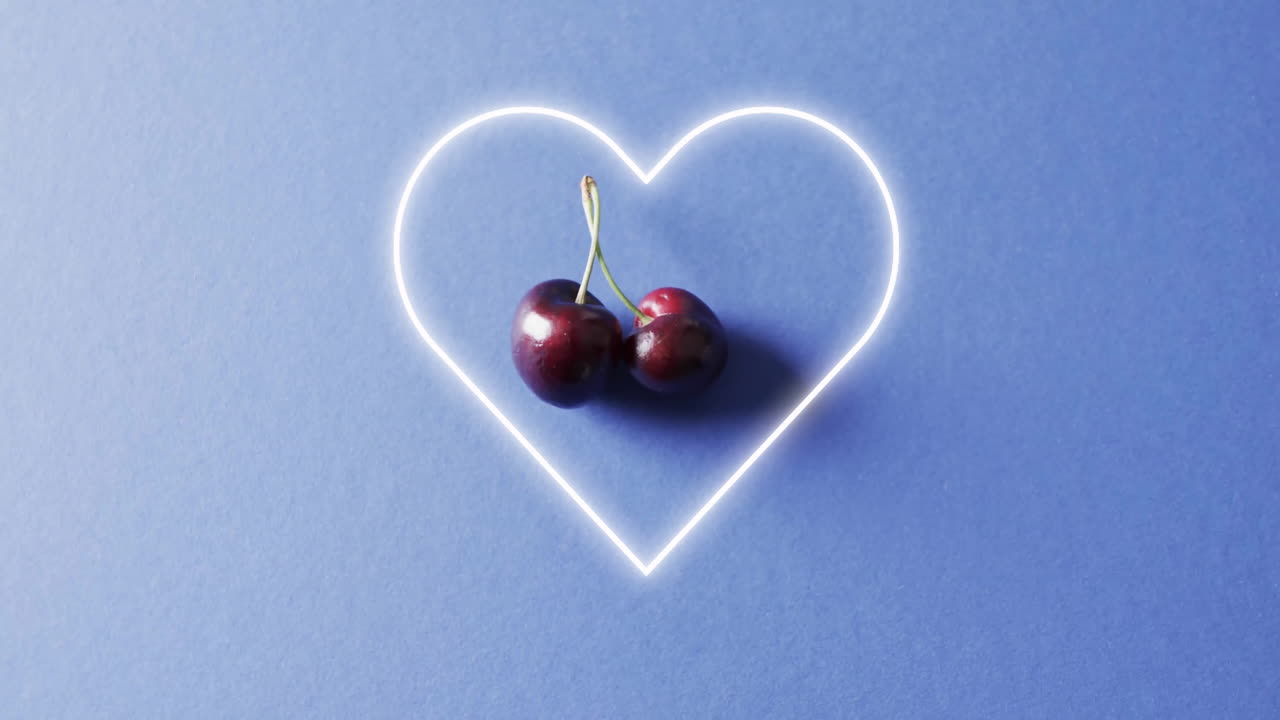 composición de cerezas y forma de corazón de neón sobre fondo azul
