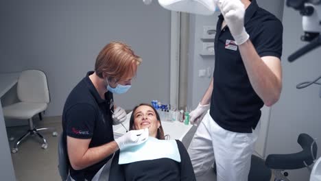 stomatologist starts treating woman's teeth. female patient opens her mouth while laying in the dental chair in modern clinic. dentistry.