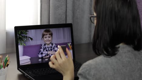 woman teacher making video call on laptop with little pupil. distance education