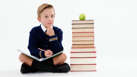 thoughtful schoolboy doing her homework