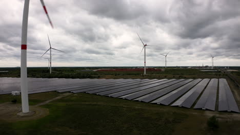 Field-of-green-energy-with-wind-and-solar-plants,-aerial-view