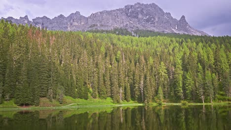 rocky mountain peak above green forest and lake, nature background