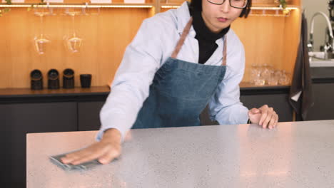 waiter cleaning bar counter with a cloth