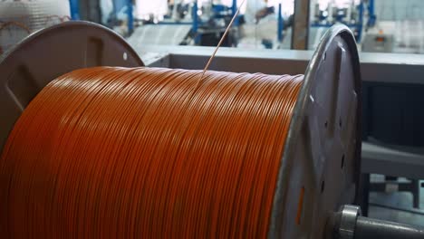 orange wire coil on reel in industrial setting