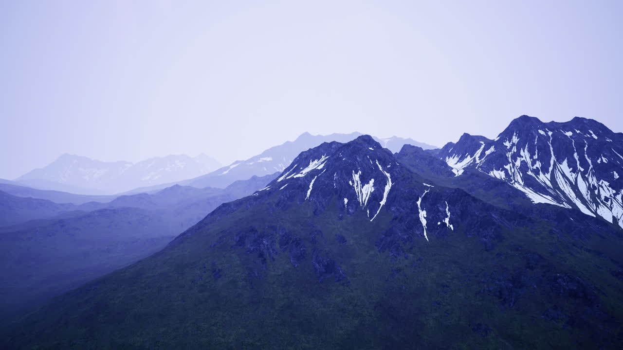 Snow covered peaks rise majestically in a tranquil mountain landscape