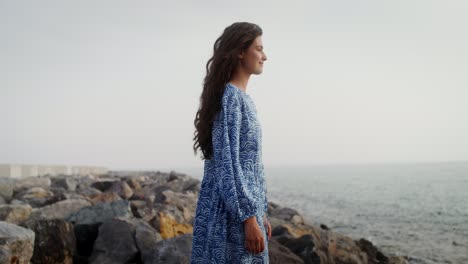 woman in a blue dress by the ocean
