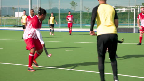 playing field hockey, male athletes competing in intense match outdoors