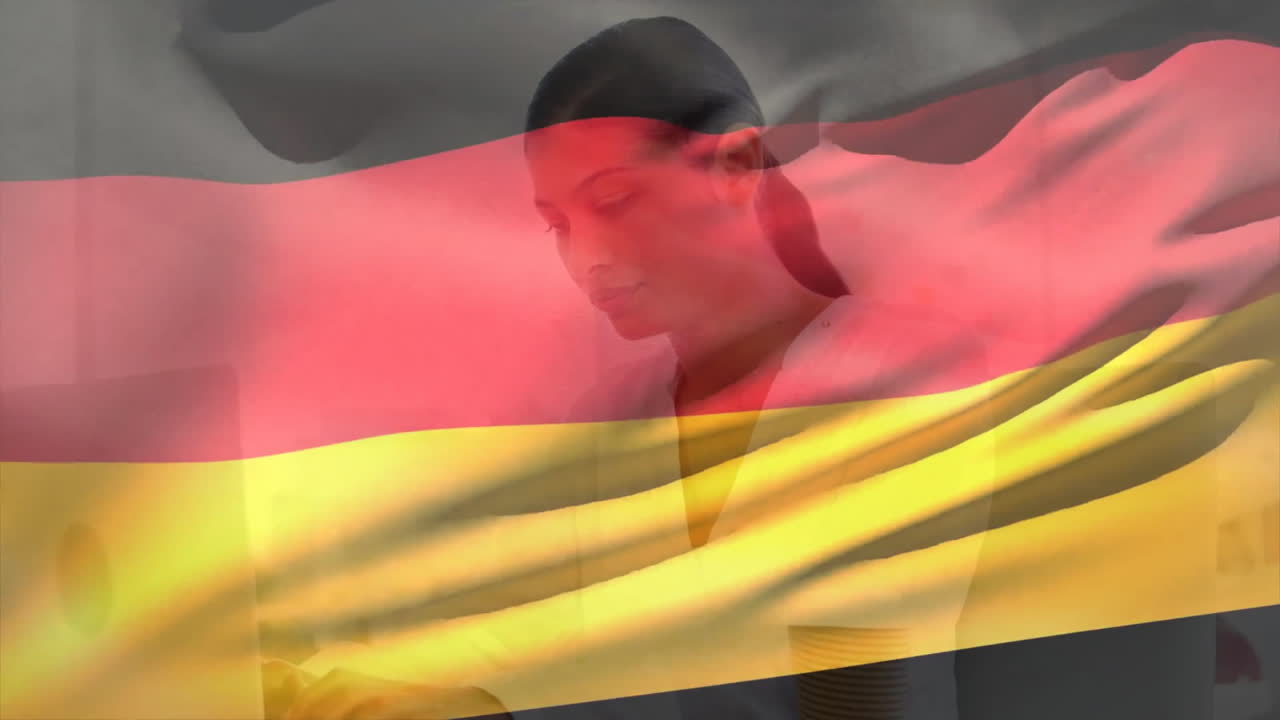 Animazione della bandiera della Germania su una donna d'affari birazziale sorridente che usa un laptop