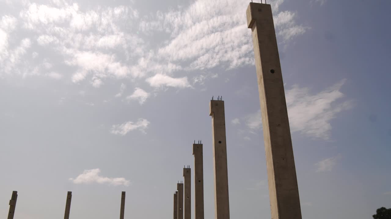 Construction site, concrete columns against a blue sky.