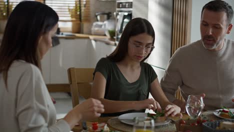 caucasian family of three sharing breakfast food together