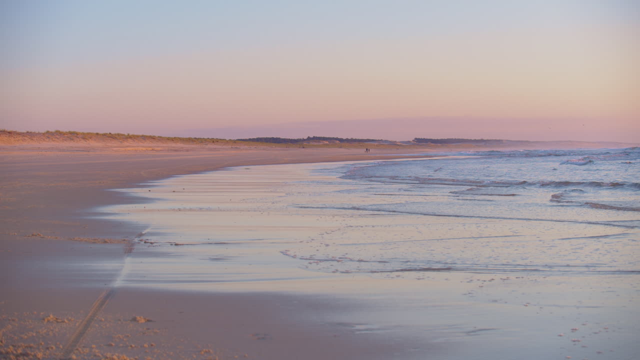 hermosa puesta de sol rosa y azul a lo largo de un tramo vacío de playa