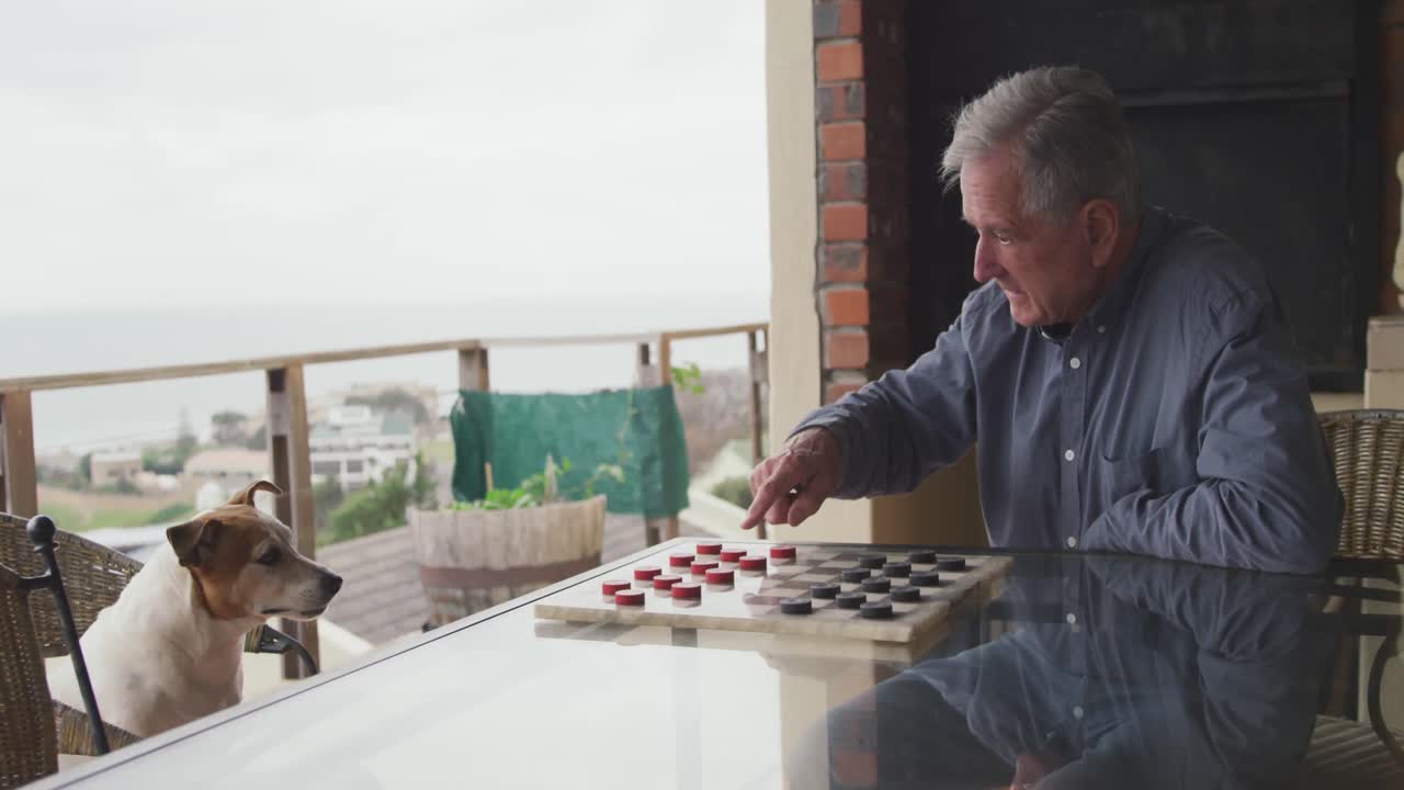 hombre mayor jugando con su perro en casa