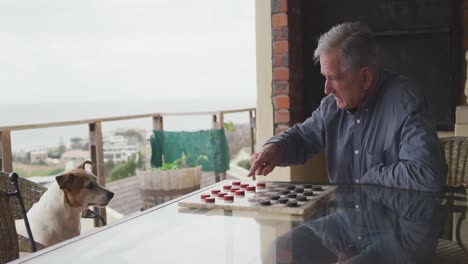 hombre mayor jugando con su perro en casa