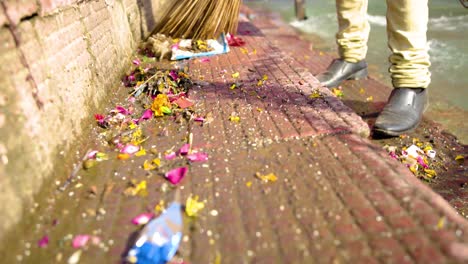 man brooming the dock of ganges river