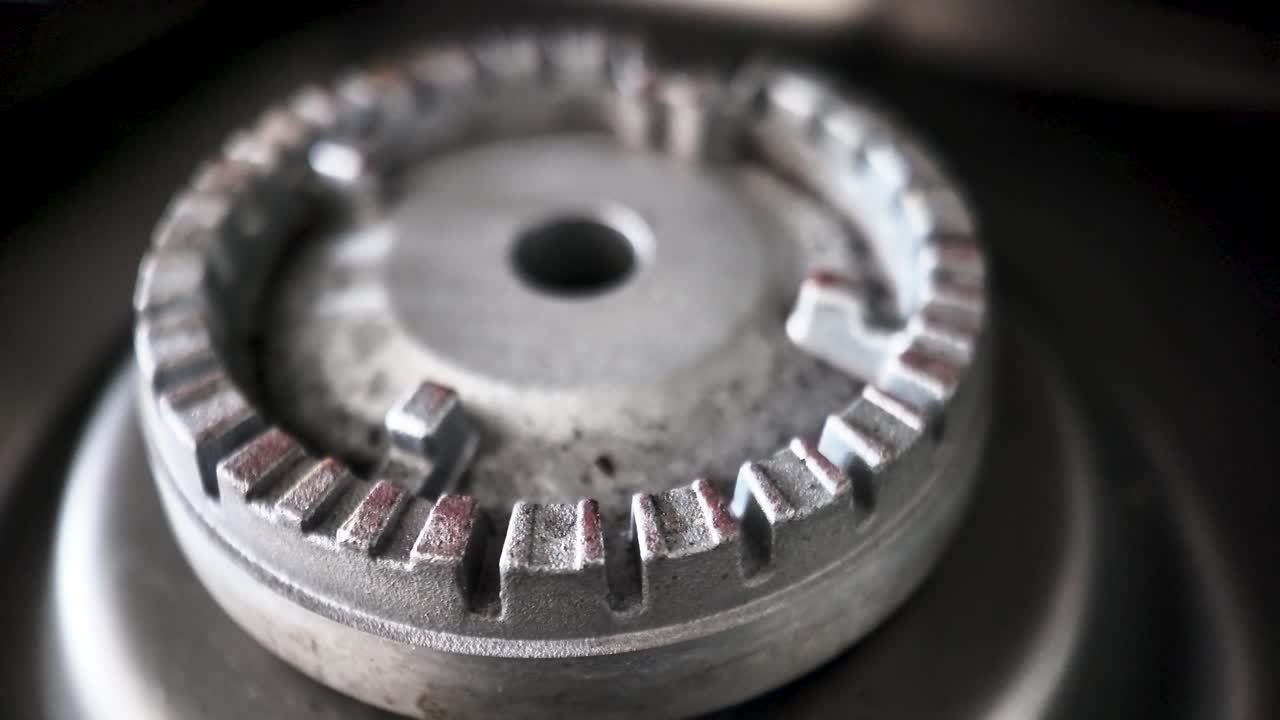 Gas cooker burner head showing rust and dirt, indicating frequent use and the need for cleaning or replacement