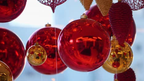 christmas and new year decoration. christmas big red balls on  background of luminous lanterns and gold garlands. holiday background. blinking garland. red baubles with lights twinkling close up.