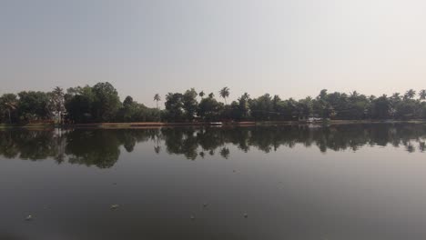 trees reflecting on river calm waters of alappuzha in india