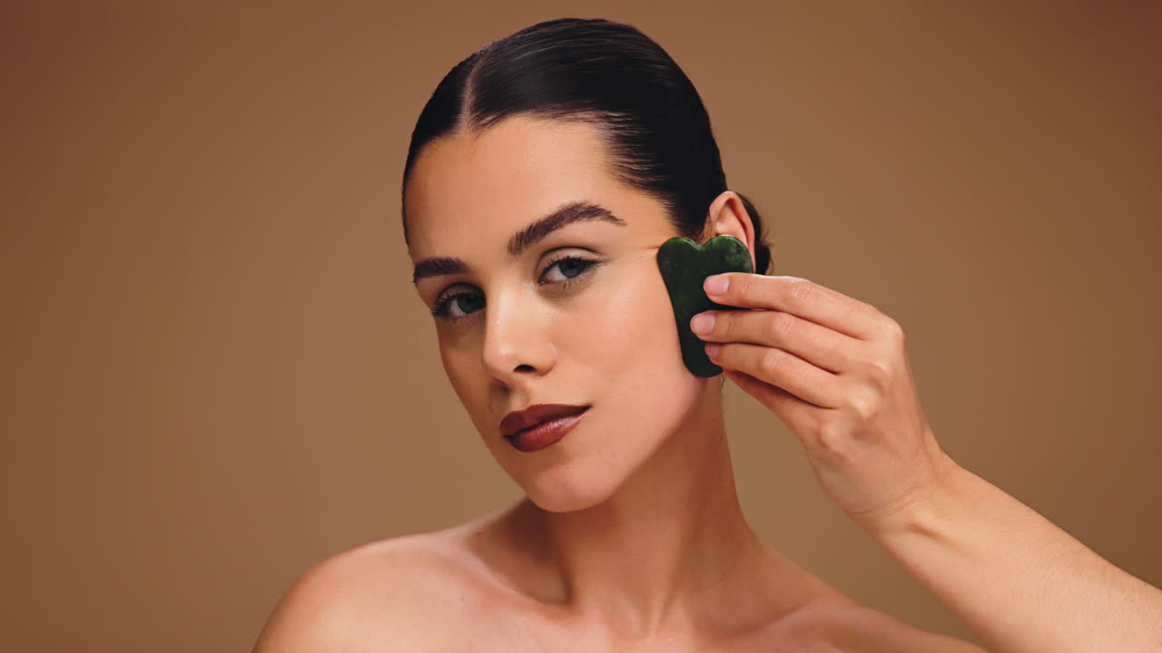 Woman using Gua Sha for facial massage