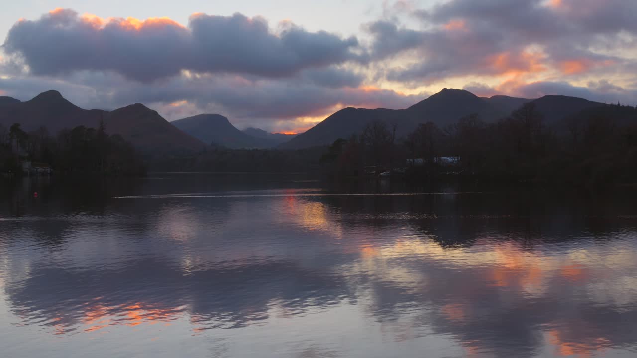 Sunset over Derwentwater in Lake District with fiery skies and mountain silhouettes