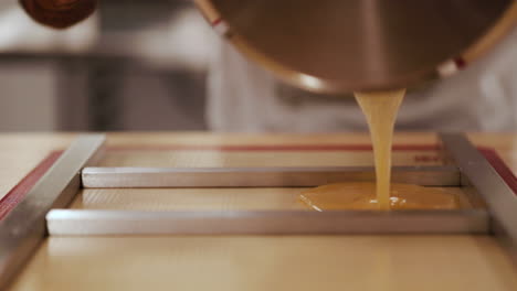 chef-pouring-hard-candy-mix-into-tray