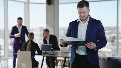 young businessman checking the information in papers and then throws them away. portrait of a confident male wearing suit. business team working at the backdrop.