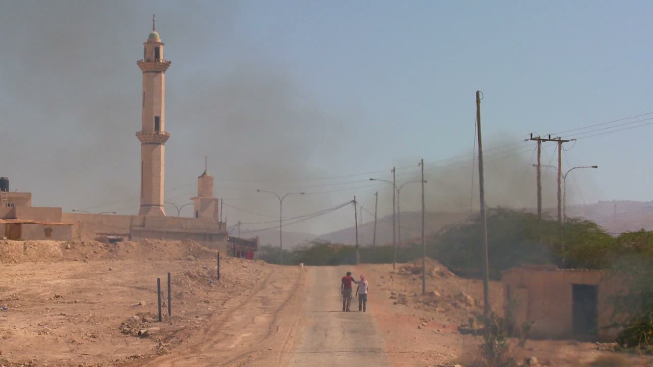 Un fuoco brucia su una strada solitaria vicino a una moschea nei Territori Palestinesi