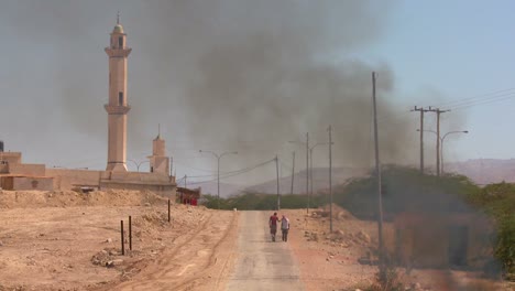 um incêndio queima em uma estrada solitária perto de uma mesquita nos territórios palestinos