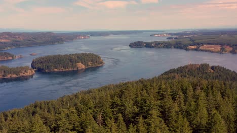 soaring above treetops: drone view of ocean islands with campbell river on the horizon