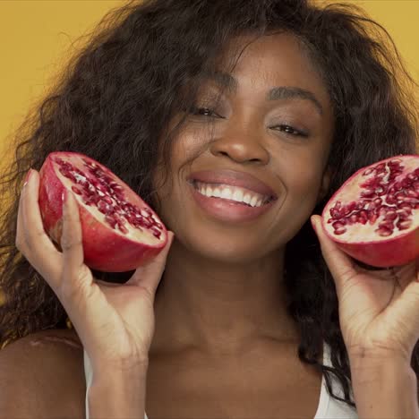 Pleased-black-woman-with-pomegranate