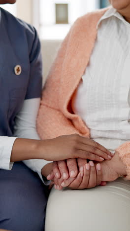 nurse holding the hand of an elderly woman