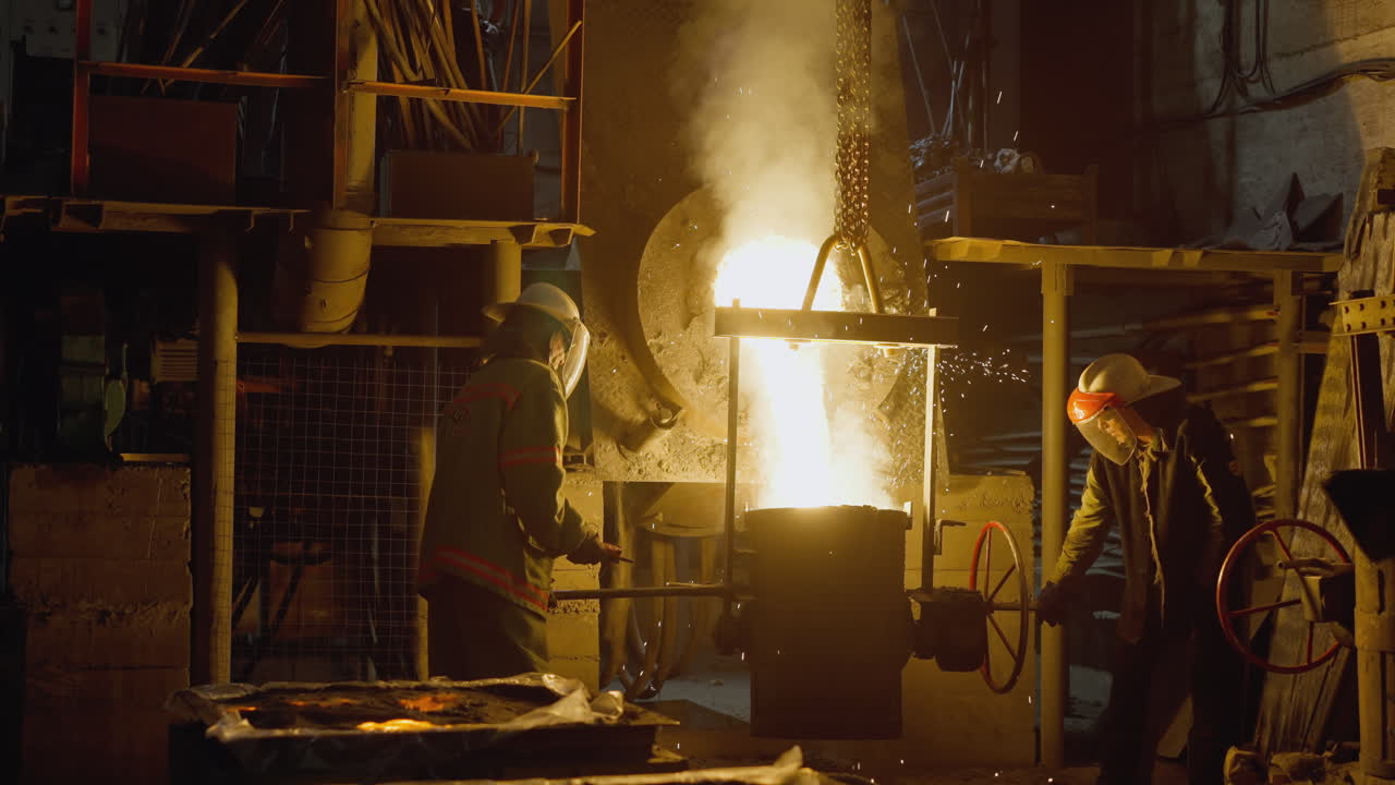 рабочие сталелитейного завода, работающие в доменной печи с мощным вспышкой пламени