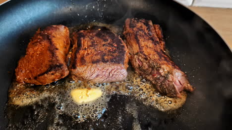 Rindersteak-In-Einer-Pfanne-Mit-Butter-Braten---Brutzelnd-Auf-Dem-Herd